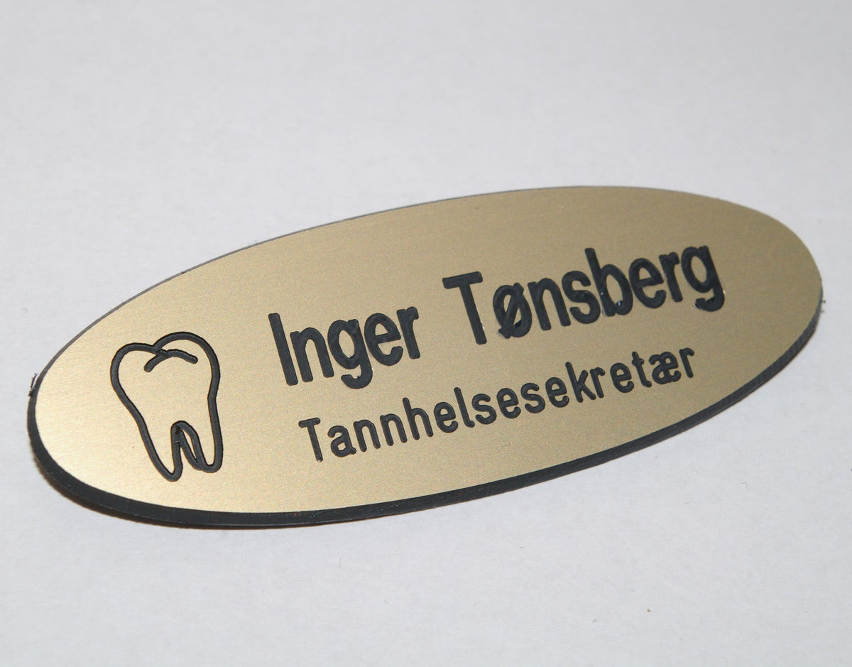 Ovalt navneskilt i gull med tannsymbol